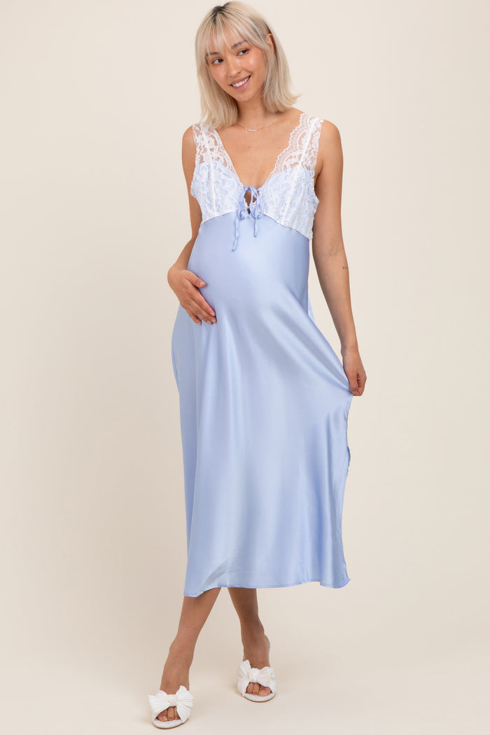woman wearing a light blue maternity nightgown with lace detailing and holding her baby bump