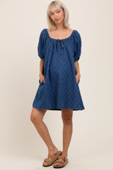 woman wearing a blue maternity dress with puff sleeves and a tie-front detail, showing a baby bump