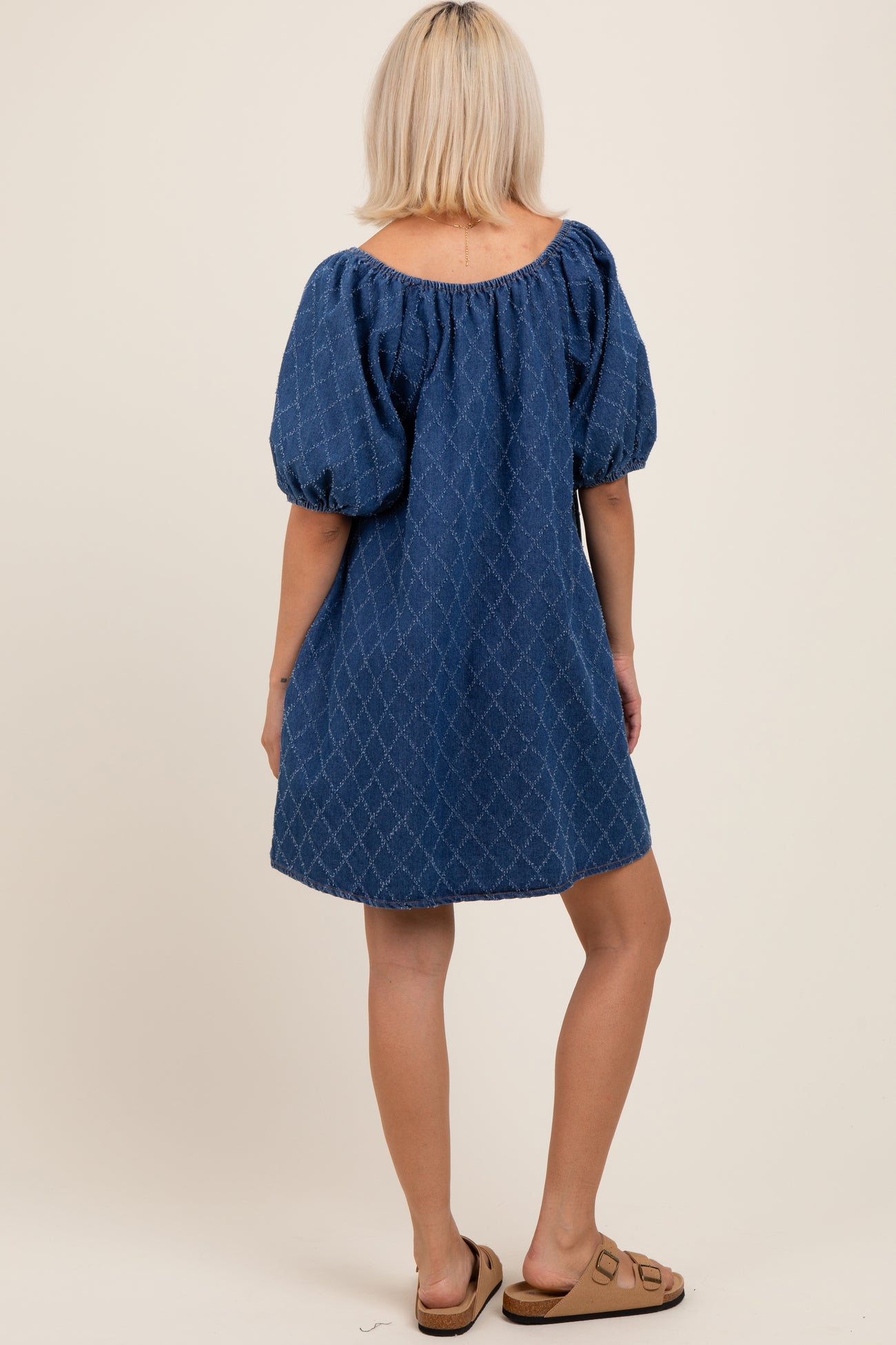 woman wearing a blue puff sleeve maternity dress with a loose fit, shown from the back
