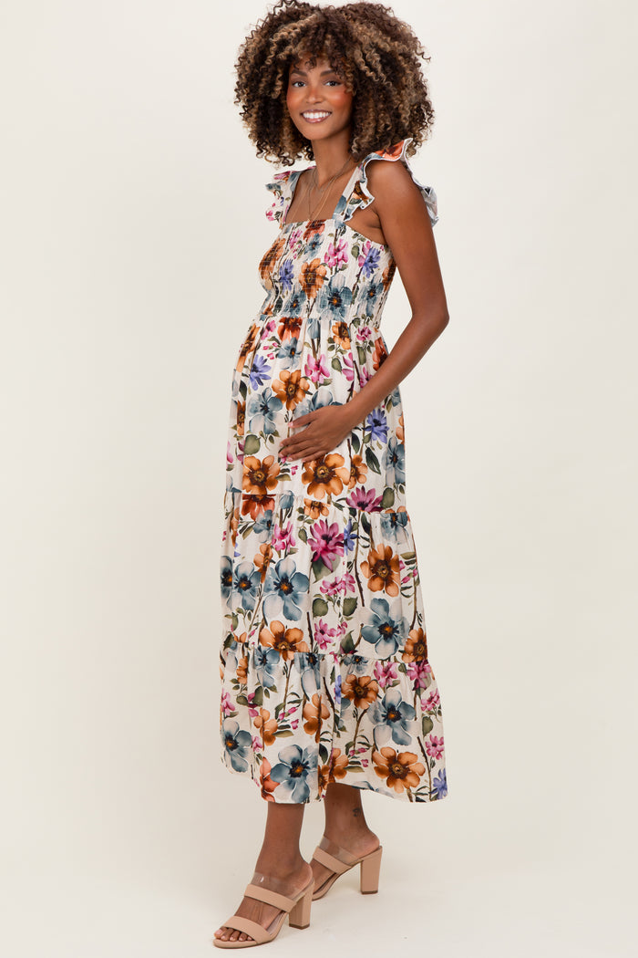 woman wearing a floral print maternity dress with ruffled straps and a visible baby bump