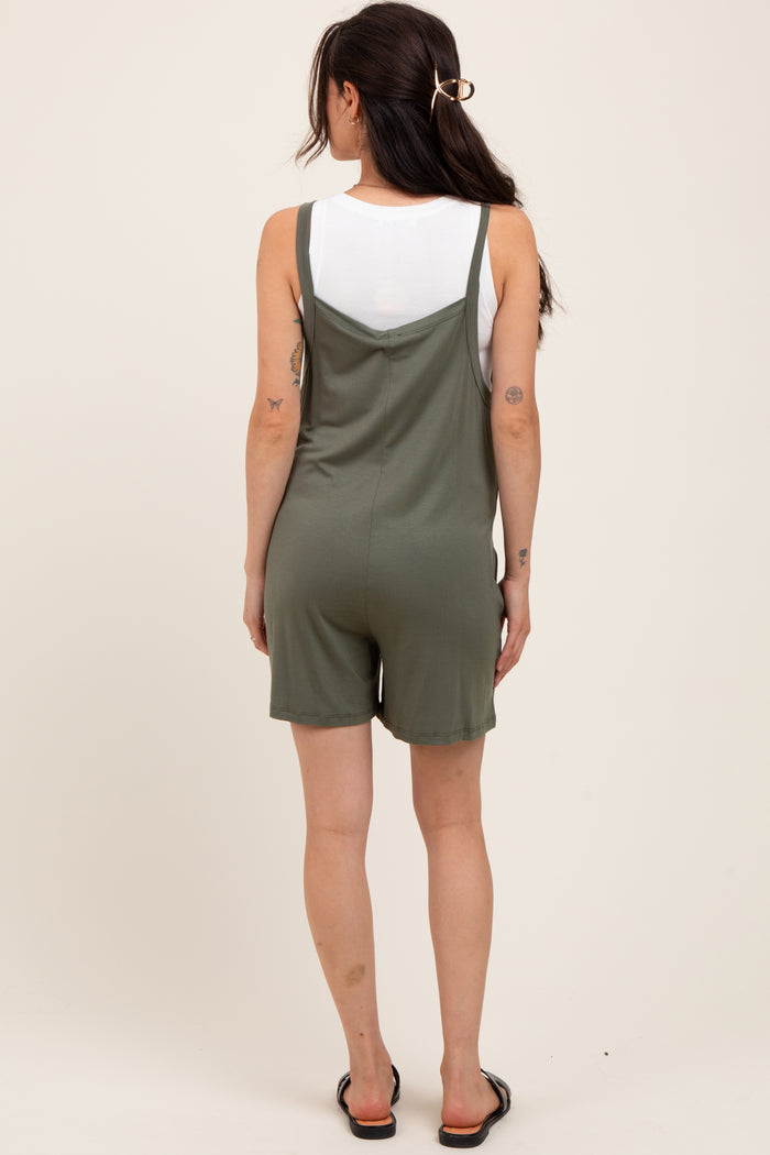 woman wearing a green maternity romper with a relaxed fit and adjustable straps, showing a casual style from the back