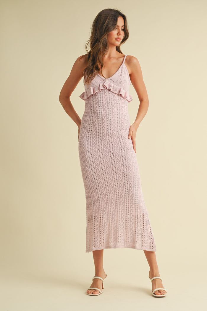 woman wearing a light pink knitted maxi dress with ruffle details and spaghetti straps