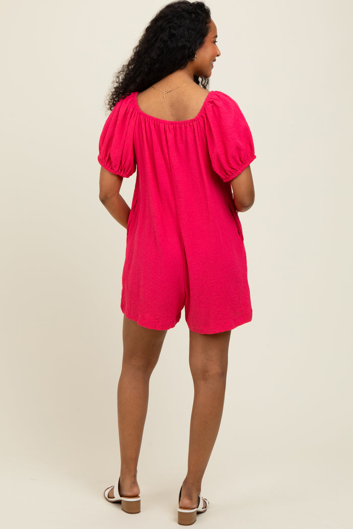 woman wearing a bright pink short romper with puff sleeves, showing the back view and styled with flat sandals
