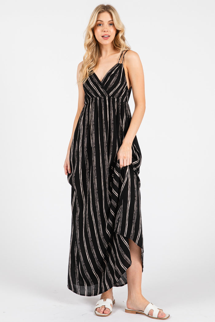 woman wearing a black and white striped maxi dress with a deep v-neck and side slit