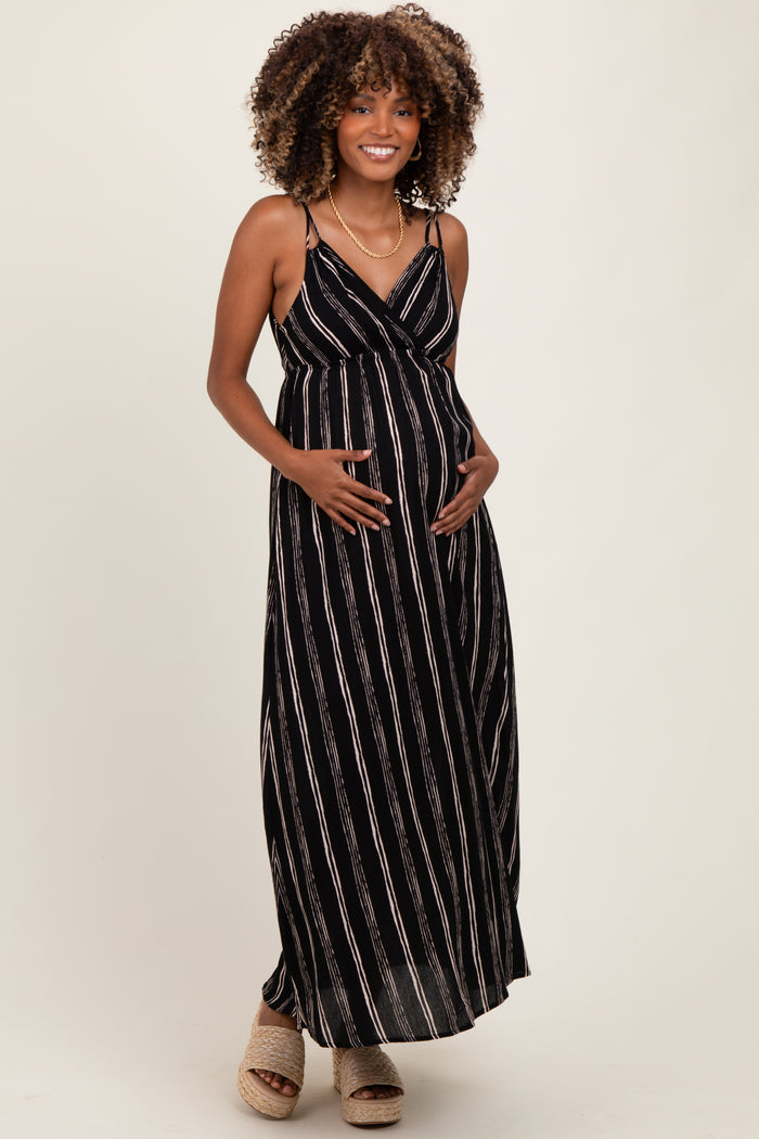 woman wearing a black and white striped maternity maxi dress, showing her baby bump with a relaxed fit