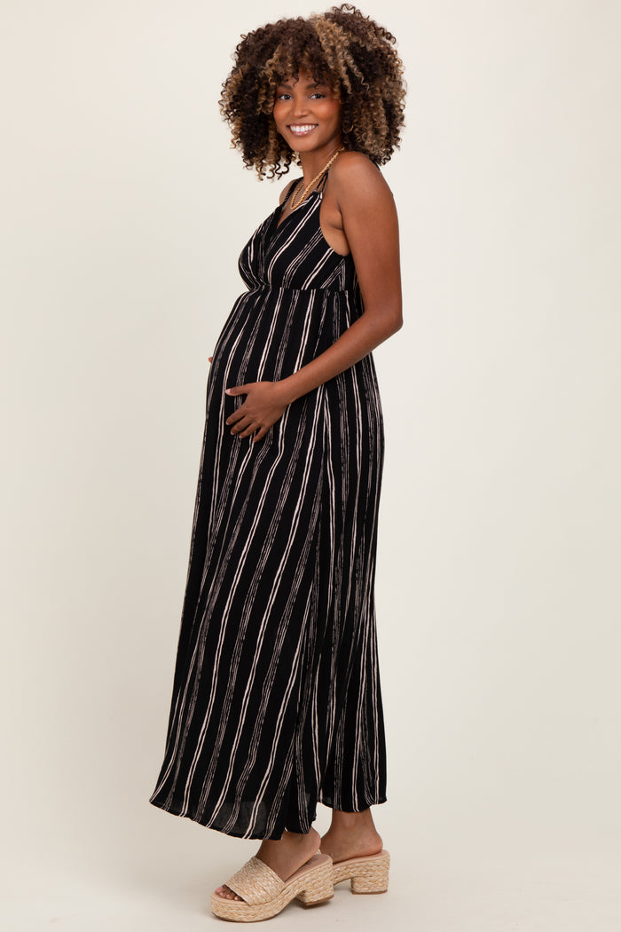 woman wearing a black and white striped maternity maxi dress and holding her baby bump