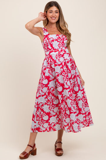 woman wearing a pink and white floral print maternity dress with a fitted bodice and flared skirt