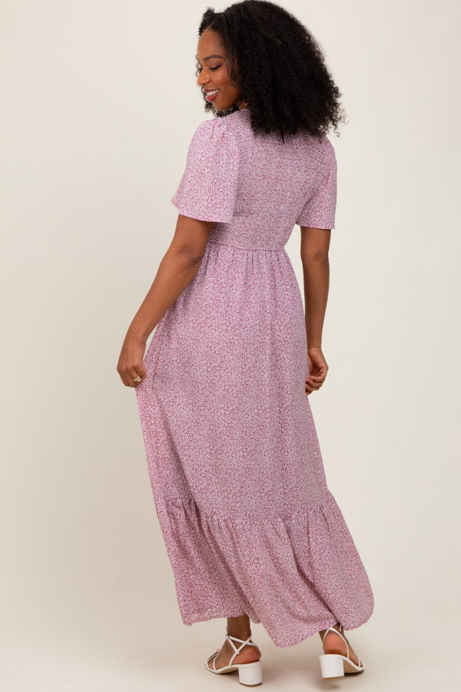 woman wearing a pink floral maxi dress with short sleeves and a tiered hem, shown from the back
