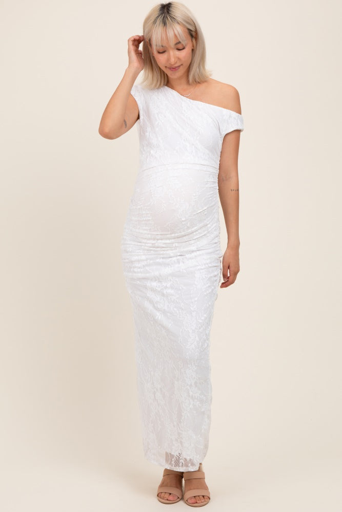 woman wearing a white lace off-shoulder maternity gown and showing her baby bump