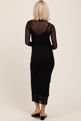woman wearing a black long sleeve maternity dress with a sheer back detail and fitted silhouette