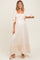 woman wearing a cream floral maternity maxi dress with puff sleeves and a square neckline, showcasing her baby bump