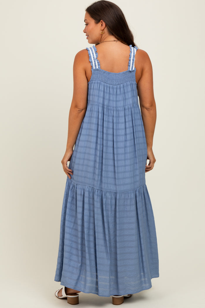 woman wearing a light blue maternity maxi dress with a smocked back and ruffled hem.