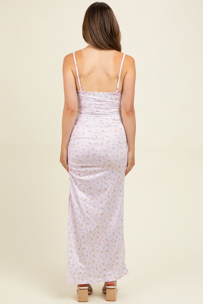 woman wearing a lavender floral maternity maxi dress with adjustable spaghetti straps and a ruched back design