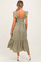 woman wearing a green and white gingham maternity dress with ruffled sleeves and a tiered hem, showing a bare back
