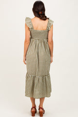 woman wearing a green and white gingham midi dress with ruffled sleeves and a smocked bodice, viewed from the back
