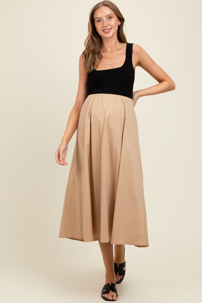 woman wearing a black and beige maternity dress with a square neckline and flowing skirt, showing her baby bump