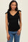 woman wearing a black ribbed tank top with tie shoulder details and a v-neck, paired with blue jeans