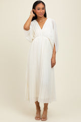 woman wearing a flowing white pleated midi dress with a deep v-neck and batwing sleeves