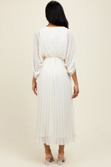 woman wearing an elegant white pleated midi dress with a cinched waist and long sleeves, viewed from the back