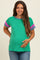 woman wearing a green maternity sweater with purple and pink striped sleeves and holding her baby bump