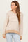 woman wearing a beige and white striped sweater with patterned sleeves and a relaxed fit