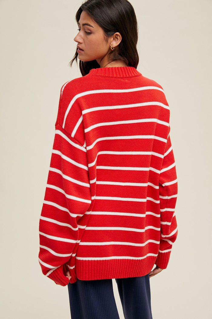 woman wearing a red and white striped oversized sweater, shown from the back