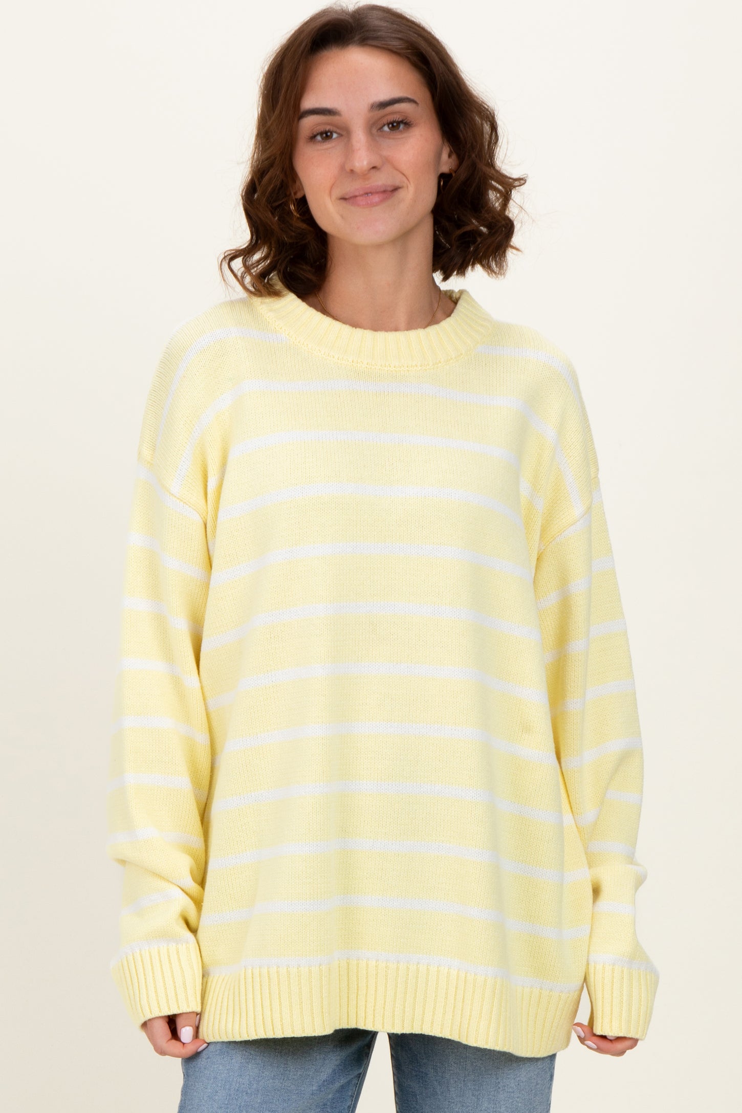woman wearing a yellow striped oversized sweater with a relaxed fit and ribbed cuffs