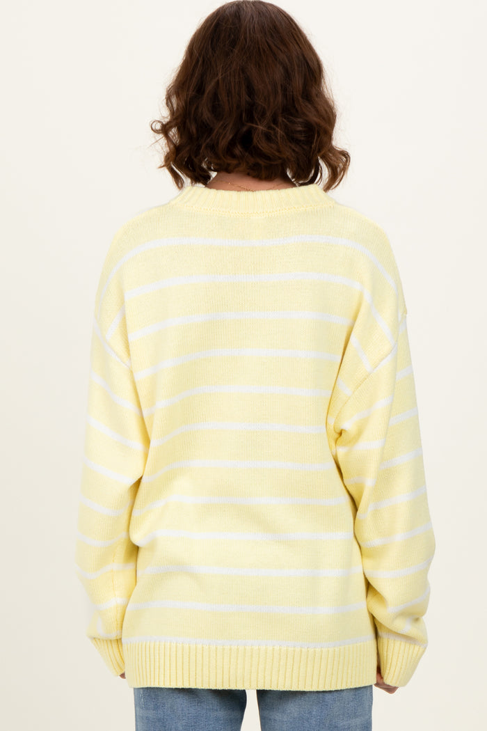 woman wearing a yellow and white striped oversized sweater, viewed from the back