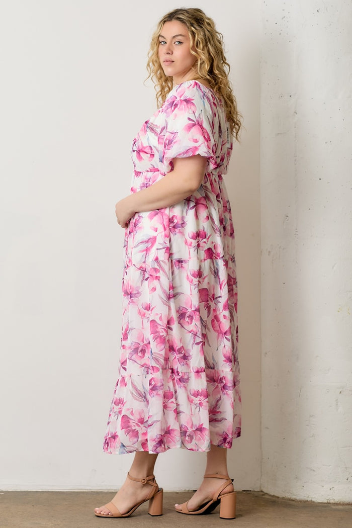 woman wearing a pink floral plus size maxi dress with short sleeves and a relaxed fit