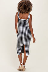 woman wearing a black and white gingham maternity dress with a slit and a square neckline, showing her back