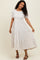 woman wearing a cream striped maxi dress with short sleeves and tiered detailing, smiling and posing
