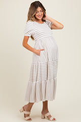 woman wearing a striped maternity maxi dress with short sleeves and pockets, showing off her baby bump