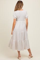 woman wearing a striped maternity dress with short puff sleeves and a tiered hem, showing a baby bump from behind