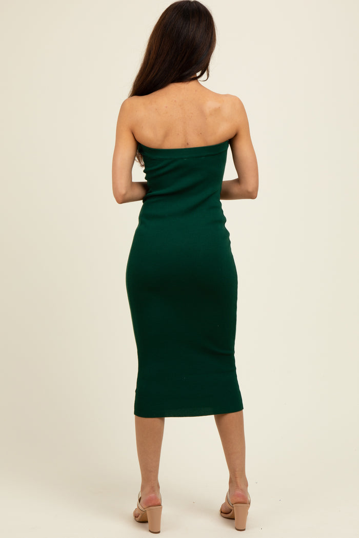 woman wearing a form-fitting dark green strapless midi dress standing with her back to the camera