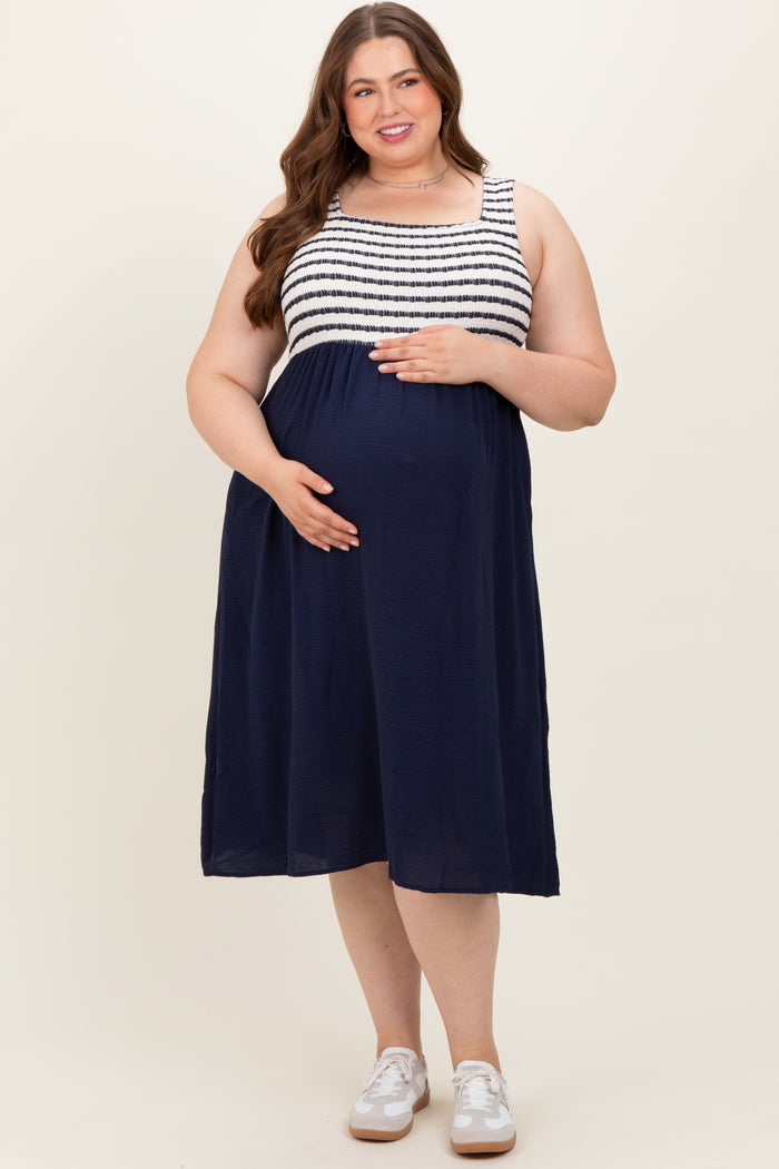 woman wearing a navy blue maternity dress with striped bodice and baby bump visible
