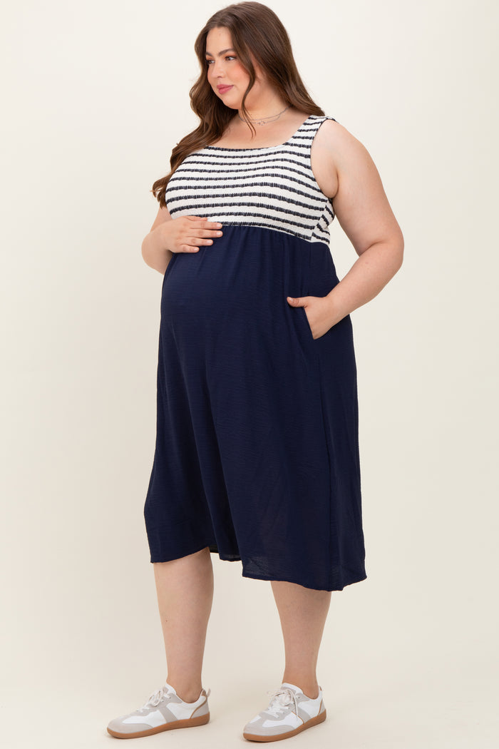 woman wearing a navy and white striped maternity dress with pockets, showing her baby bump
