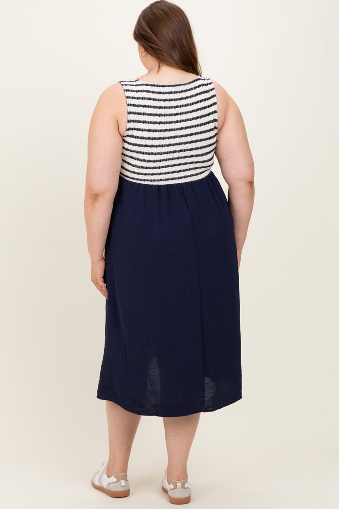 woman wearing a navy and white striped maternity plus dress with a fitted bodice and flowing skirt, shown from the back