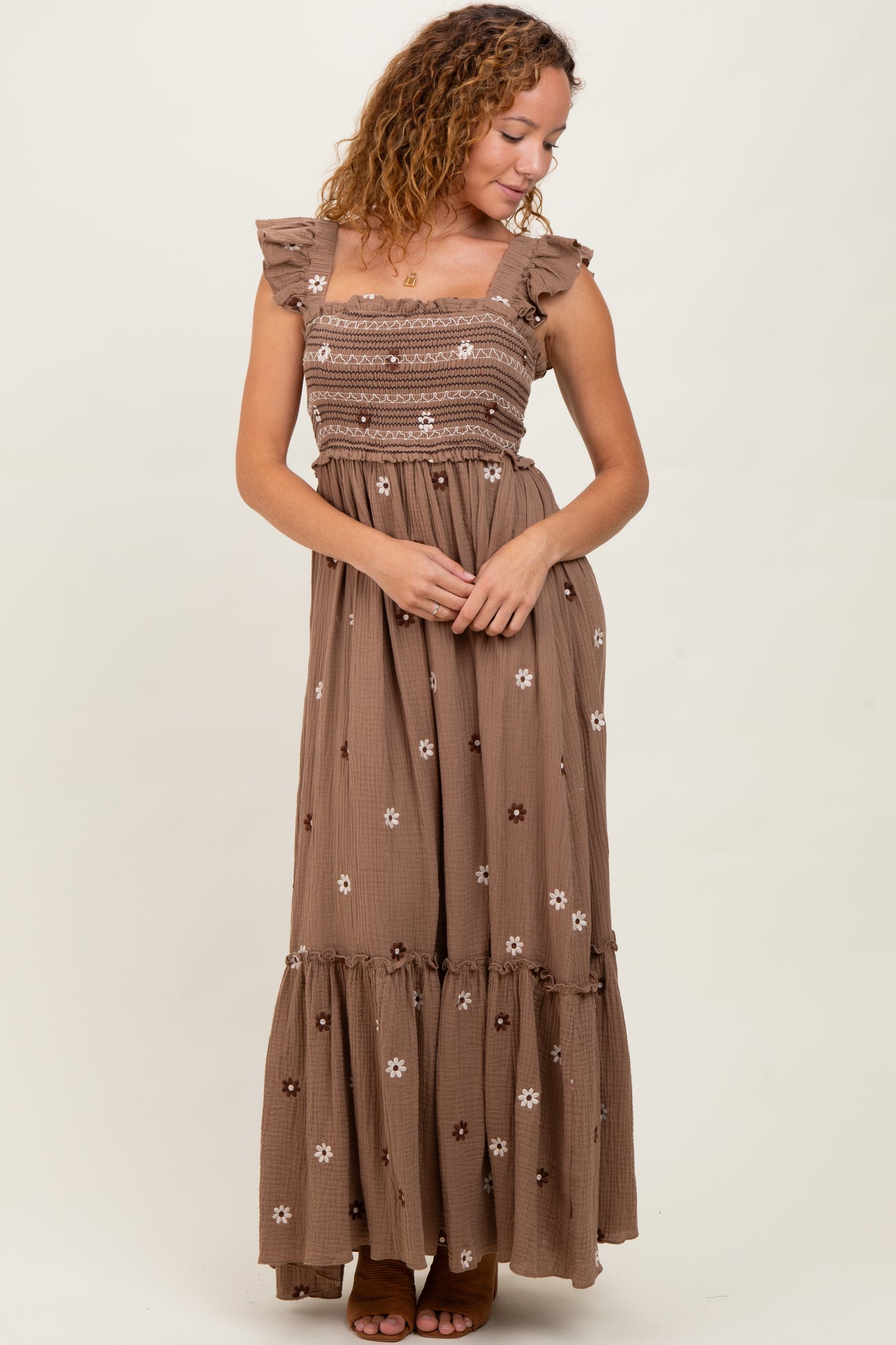 woman wearing a brown floral maxi dress with ruffled straps and tiered skirt