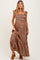 woman wearing a brown floral maternity maxi dress with ruffled sleeves and a smocked bodice, showcasing her baby bump