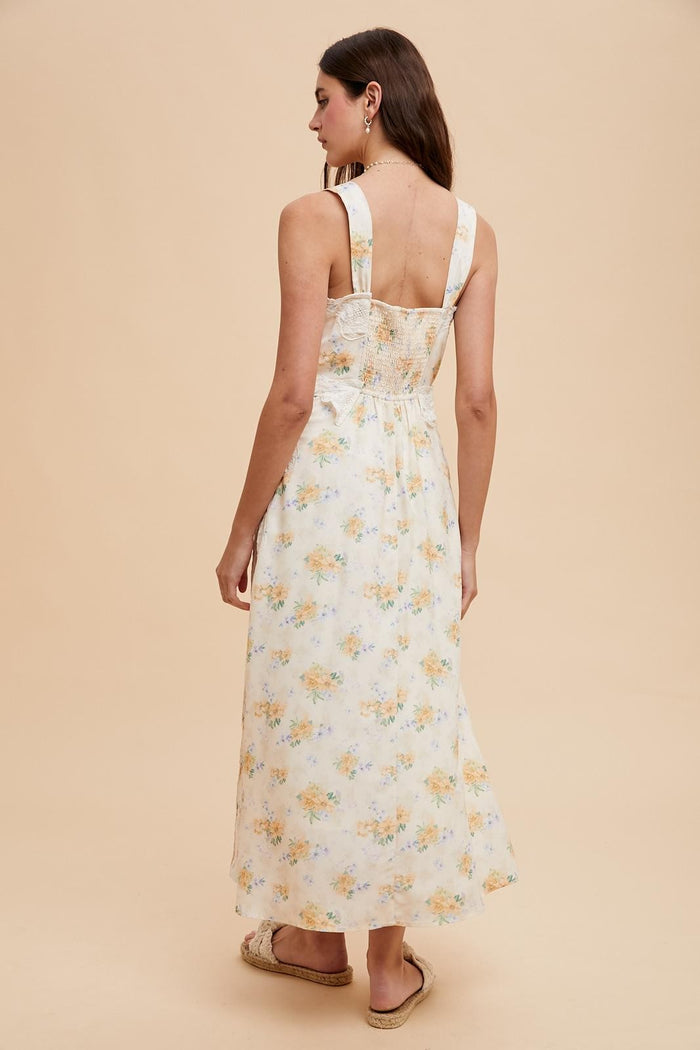 woman wearing a floral print backless maxi dress with a smocked bodice and adjustable straps