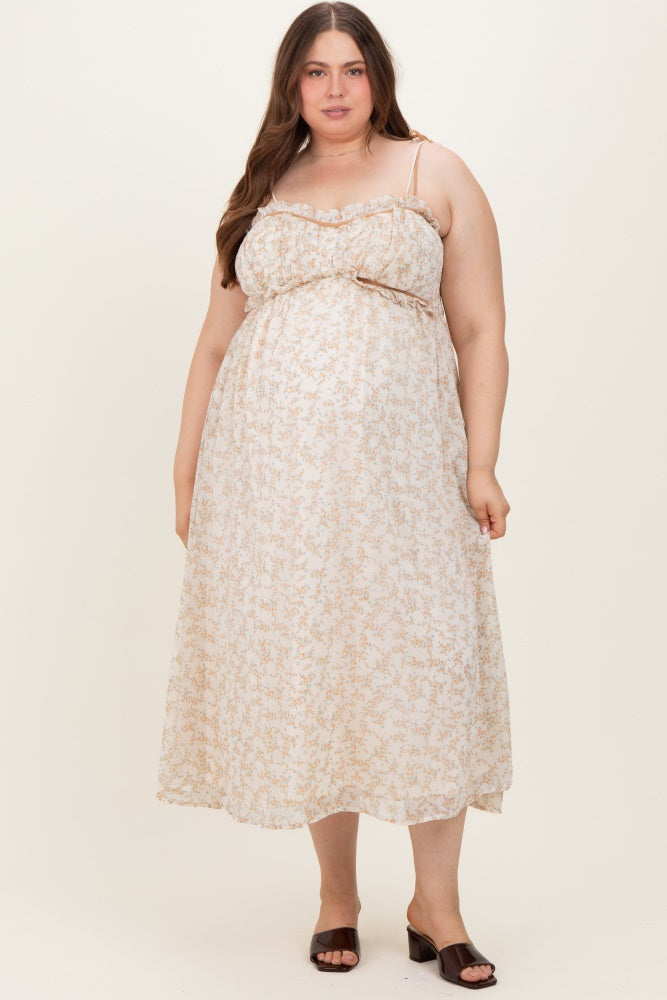 woman wearing a light floral maternity plus dress with adjustable straps, showcasing her baby bump