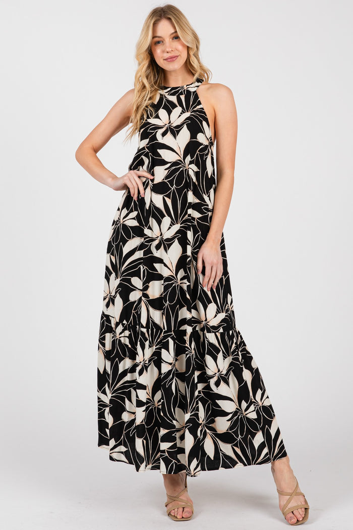 woman wearing a black and white floral maxi dress with a halter neck and flowing skirt