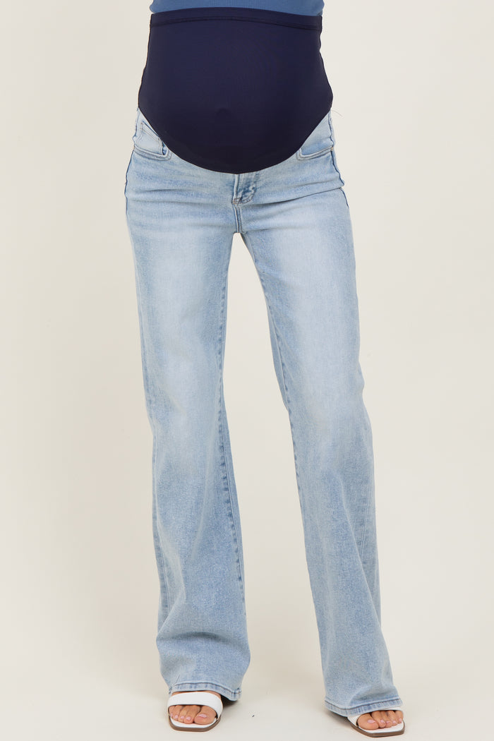woman wearing light blue maternity flare jeans with a visible baby bump
