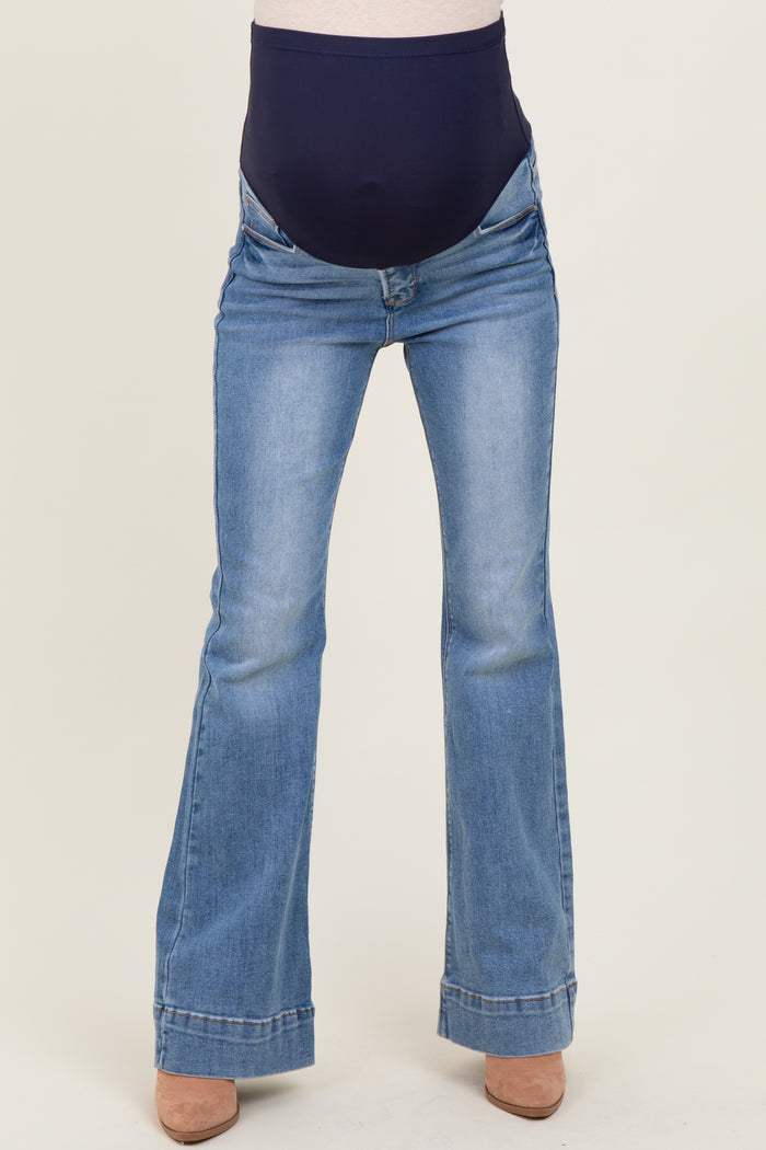 maternity wear light wash flared jeans with a navy blue over-the-belly panel, model not shown wearing them
