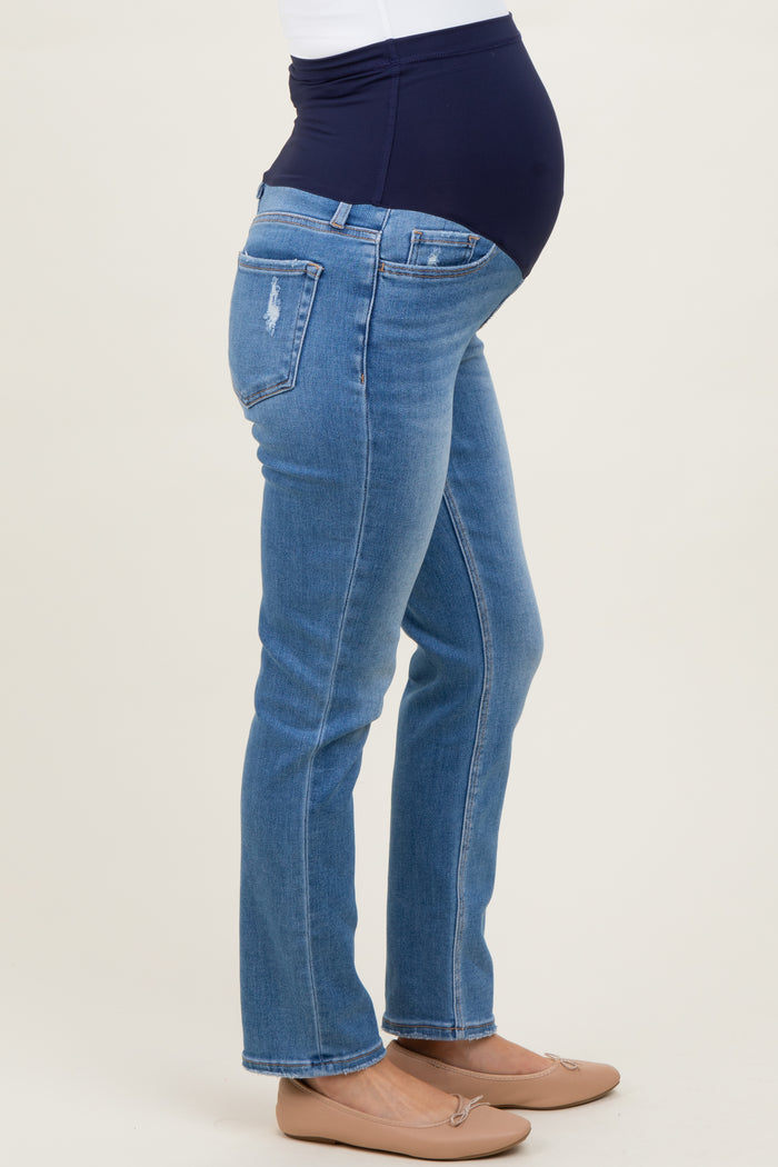 woman wearing maternity blue jeans with a navy blue over-the-bump waistband and a visible baby bump