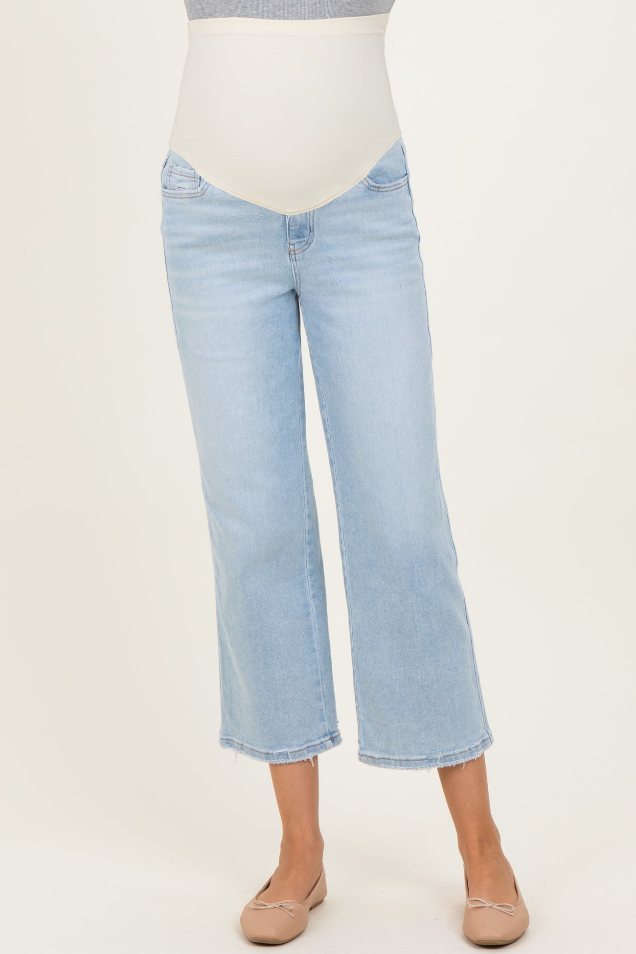 woman wearing light blue maternity wide-leg jeans with a stretchy waistband and beige ballet flats
