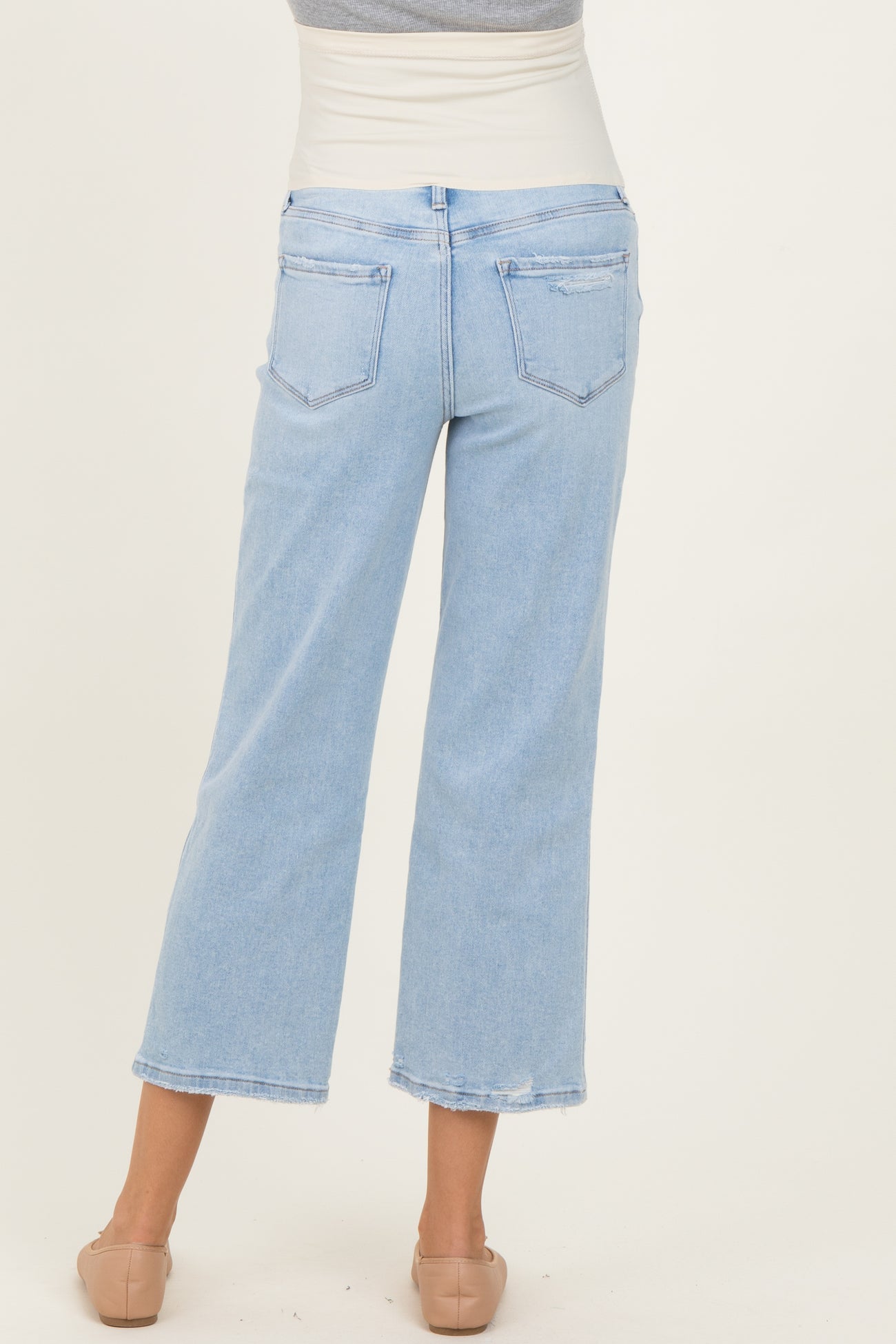 woman wearing light blue maternity wide-leg jeans, showing the back view with a relaxed fit