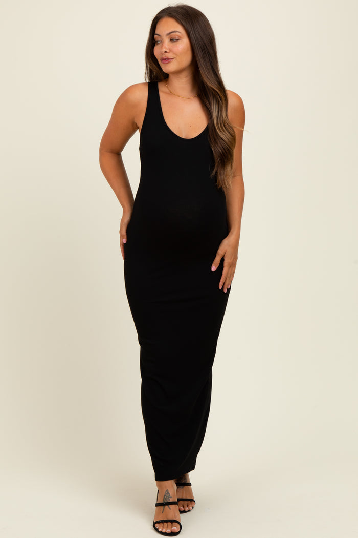 woman wearing a black ribbed sleeveless maternity maxi dress and showing her baby bump