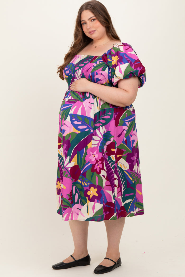 woman wearing a vibrant floral print maternity dress with puff sleeves and a hand on her baby bump
