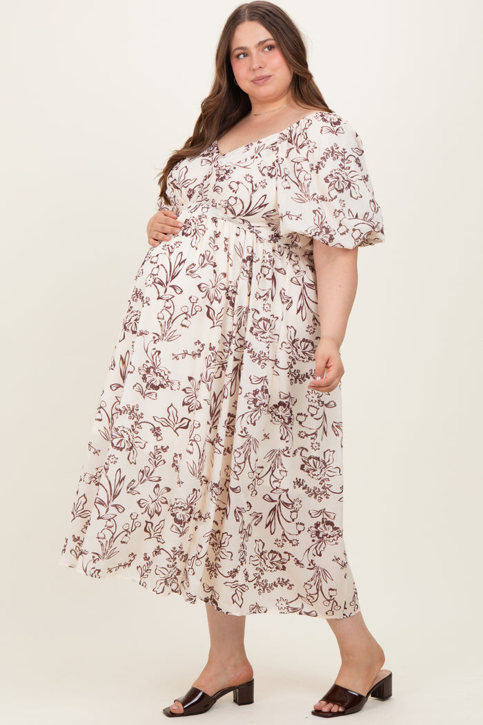 woman wearing a cream floral maternity maxi dress with short ruffled sleeves and a baby bump visible